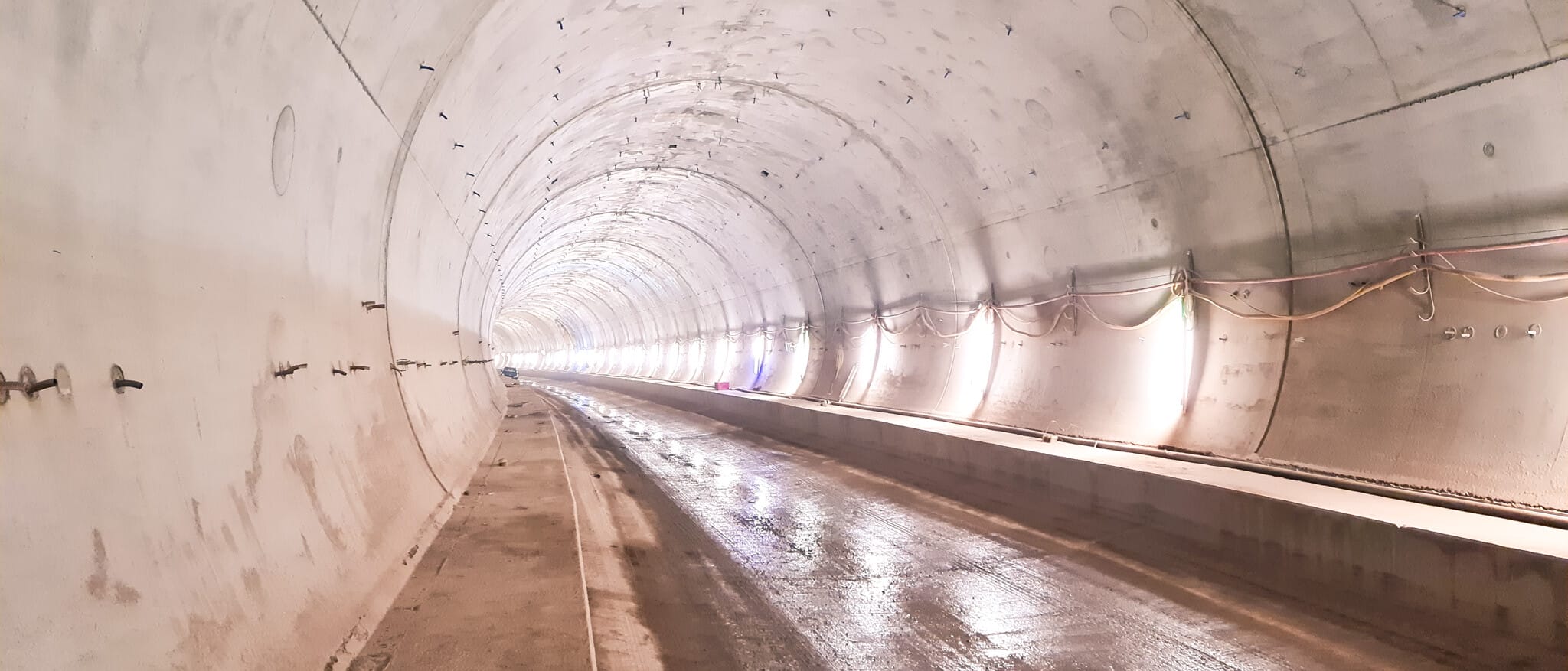 Blick in eine im Rohbau befindliche Tunnelröhre mit Baustellenbeleuchtung