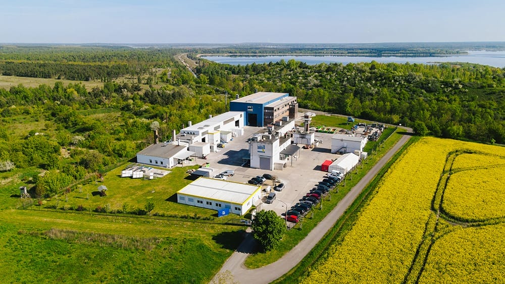 Drohnenaufnahme der Brandprüfstelle in Laue bei Delitzsch mit einem gelben Rapsfeld und einem See im Hintergrund